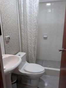 y baño con aseo, lavabo y ducha. en HOSTAL QENQO, en Tacna