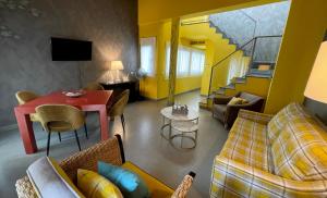 a living room with a red table and a yellow wall at Ritual Sevilla Suites - Malaver 23 in Seville