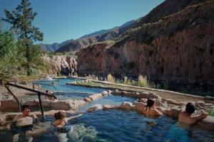 a group of people in a hot tub in a canyon at Apartamento Deluxe Senderos del Vino IV, Desayuno Opcional in Mendoza