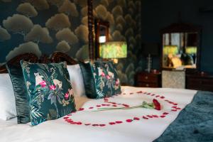 a white bed with a flower decoration on it at No11 Boutique Hotel & Brasserie in Edinburgh