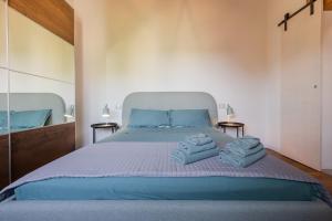 een slaapkamer met een groot bed en handdoeken bij Corte Odorico in Pedemonte