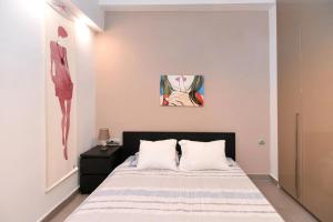 - une chambre avec un lit et une peinture murale dans l'établissement Excellent apartment luxuriously renovated, à Larissa