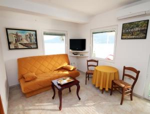 ein Wohnzimmer mit einem Sofa und einem Tisch in der Unterkunft Apartmani Kukoljac in Herceg-Novi