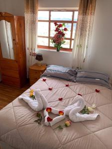 een bed met handdoeken en bloemen en een raam bij Summit Viewpoint House San Blas in Cuzco