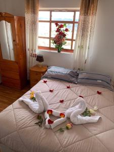 ein Bett mit Handtüchern und Blumen sowie einem Fenster in der Unterkunft Summit Viewpoint House San Blas in Cusco