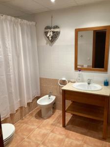 een badkamer met een toilet en een wastafel bij El Pico del Sombrero, tu lugar para desconectar. in Mora de Rubielos
