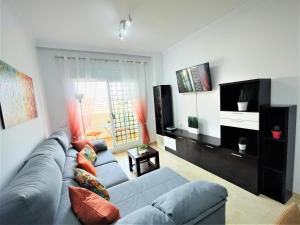 ein Wohnzimmer mit einem Sofa und einem TV in der Unterkunft ARENAL GOLF HOME in Benalmádena
