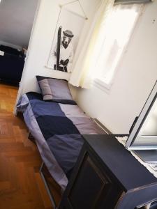 ein kleines Bett in einem Zimmer mit Fenster in der Unterkunft Apt confortable au pied des pistes et de la forêt in Bolquere