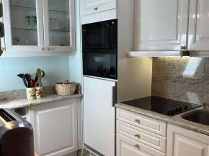 una cocina blanca con armarios blancos y fregadero en Appartement Megève, 2 pièces, 4 personnes - FR-1-597-169, en Megève