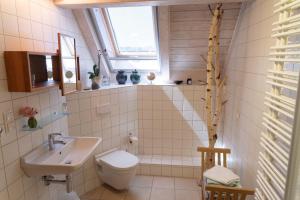 a bathroom with a sink toilet and a window at Ferienwohnung-Spessart in Straßbessenbach