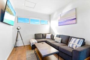a living room with a couch and a table at 2Bdrm Beachside Town House with Ocean Views in Seaford