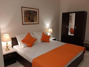 a bedroom with a bed with orange and white pillows at Colonel's Abbey in Jaipur