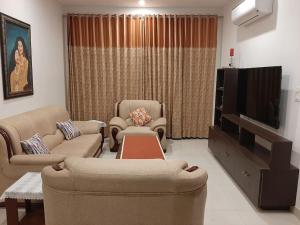 sala de estar con 2 sofás y TV en Colonel's Abbey, en Jaipur
