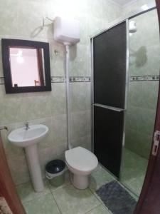 łazienka z toaletą i umywalką w obiekcie Pousada Tuiuti w mieście Tramandaí