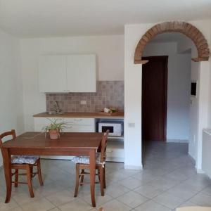 una cocina con mesa, sillas y un arco en La Finestra Verde, en Montignoso