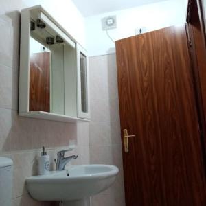 uma casa de banho com um lavatório, um espelho e um WC. em La Finestra Verde em Montignoso