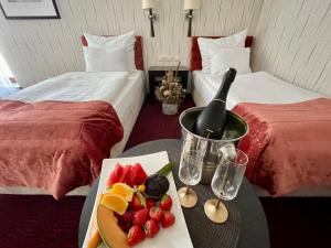 una habitación de hotel con una mesa con una botella de vino y fruta en Hotel Silvia Gold Gliwice, en Gliwice