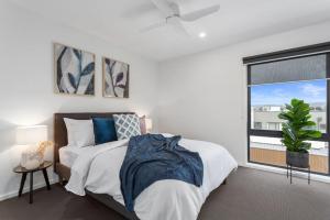 1 dormitorio con cama y ventana grande en Modern Spacious Coastal 4 Bedroom Town House, en Safety Beach