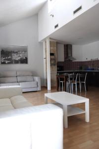 een woonkamer met een witte bank en een tafel bij Vivienda Turística Yamaries in Úbeda