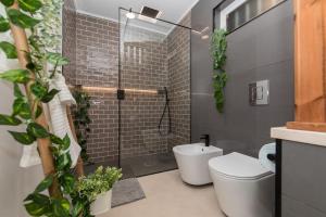 ein Bad mit einem WC und einer Dusche mit Pflanzen in der Unterkunft Casa A-Mar in Sesimbra