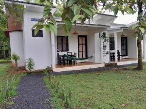 a white house with a porch and a yard at Hibiscus Garden in Santa Catalina