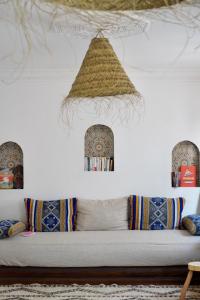 um quarto com um sofá com almofadas e um tecto em Moana Surf Maroc em Tamraght Ouzdar