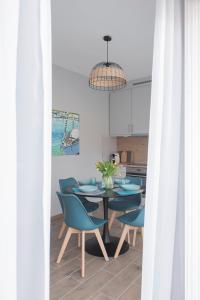 a dining room with a table and blue chairs at Aranygesztenye Apartmanház in Balatonudvari
