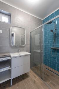 y baño con lavabo y ducha acristalada. en Aranygesztenye Apartmanház, en Balatonudvari