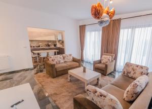 Penthouse Luxury Falticeni في فالتيسيني: غرفة معيشة مع أريكة وكراسي وطاولة