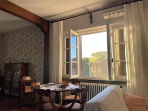 a living room with a table and a large window at Villa Verde in Camaiore
