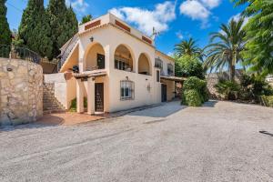 a large white house with a driveway at Villa Rodrigo - PlusHolidays in Benissa