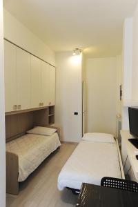two beds in a room with white cabinets at Le Gemme 1 in Empoli