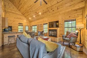 a living room with a couch and a fireplace at Cabin with Games and Hot Tub, 4 Mi to Beavers Bend! in Broken Bow