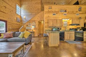 uma sala de estar com um sofá e uma cozinha numa cabina em Cabin with Games and Hot Tub, 4 Mi to Beavers Bend! em Broken Bow