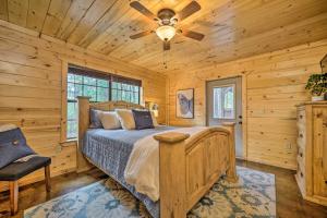 Cabin with Games and Hot Tub, 4 Mi to Beavers Bend! في بروكن بو: غرفة نوم بسرير ومروحة سقف