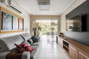 sala de estar con sofá y TV de pantalla plana en Lindo Apto no Terraços da Rainha, en Balneário Camboriú