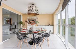 a dining room with a table and chairs at Lindo Apto no Terraços da Rainha in Balneário Camboriú