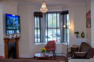 a living room with a couch and chairs and windows at Royale Green View House- free parking, Wifi, Perfect for Contractors and Holiday in Northampton