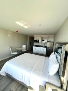 a large white bed in a room with a kitchen at Queen of Charm Luxury Suite Downtown Hartford Location!Location!Location! in Hartford