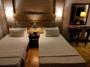 um quarto de hotel com duas camas e um espelho em The Exclusive House em Peshawar
