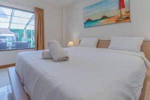 un grande letto bianco in una camera da letto con finestra di Resort 6-3BR Huge Pool, BBQ, 300m-Beach, 8 mins to Walking Street a Pattaya Sud Altre 27 foto