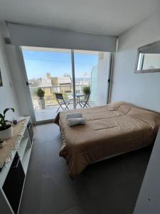 a bedroom with a large bed and a large window at Monoambiente frente al río en Ramallo in Ramallo