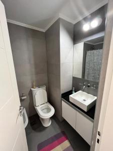 a bathroom with a white toilet and a sink at Monoambiente frente al río en Ramallo in Ramallo