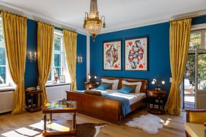 1 dormitorio con 1 cama y paredes y ventanas azules en Luxus Hotel Design Villa Ottilienruh Ilsenburg im Harz, en Ilsenburg