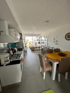 a kitchen and living room with a table and a dining room at Monoambiente frente al río en Ramallo in Ramallo