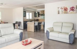 a living room with two white couches and a kitchen at Holiday Home Louargat I in Louargat