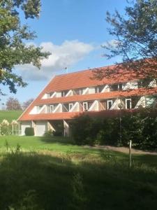 a large red and white building with a red roof at Bruinisse-Zeeland-Holland in Bruinisse