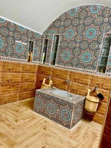 a bathroom with a sink and a tile wall at Jnane Nina in Tagadirt