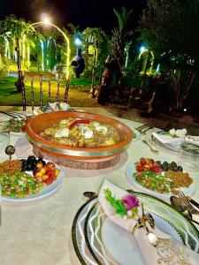 einen Tisch mit Teller mit Lebensmitteln darüber in der Unterkunft Jnane Nina in Tagadirt