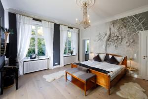 a bedroom with a bed and a chandelier at Hotel Design Villa Ottilienruh in Ilsenburg